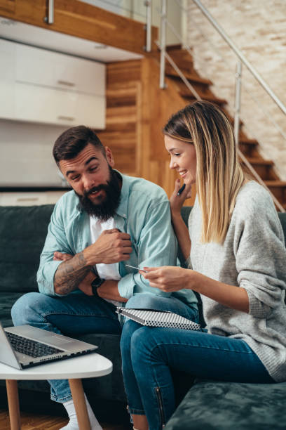 istock Couple using laptop while going through their finances and bills together at home 1318457673