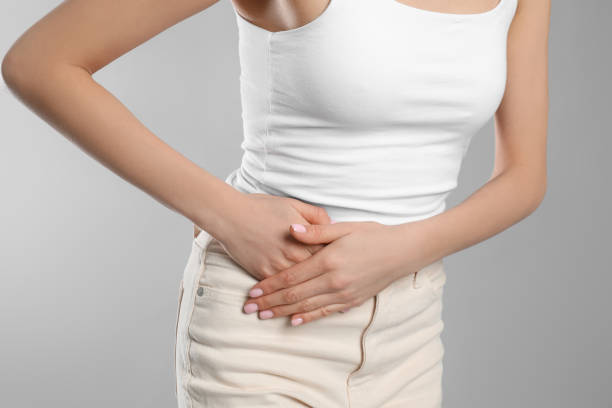 istock Woman suffering from appendicitis inflammation on grey background, closeup 1318458466