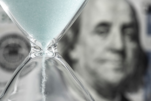 Benjamin Franklin looking at hourglass.