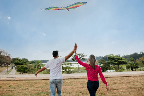 istock Couple having fun flying a kite 1318458945