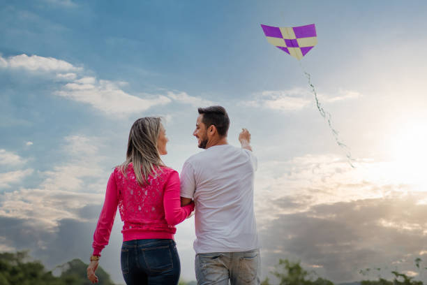 istock Couple having fun flying a kite 1318459131