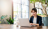 オフィスデスクの仮想コンピュータで働くピンクのスーツを着た美しいビジネスアジアの女性を笑顔。中小企業経営者従業員フリーランスオンラインスメマーケティング電子商取引テレマー�
