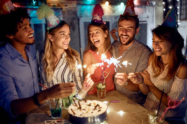 group of friends enjoying sprinklers at the open air birthday party. quality friendship time together - city night lighting equipment mid air imagens e fotografias de stock