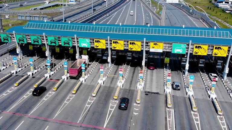 Toll roads on the broad highway. Through the point passes a large number of trucks and cars. Top down view of a quadcopter