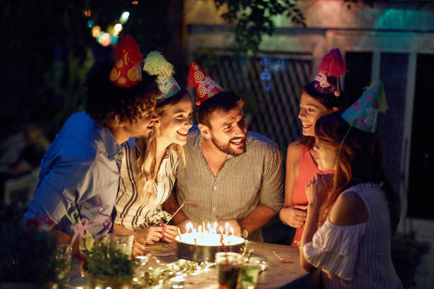 a young girl, friends and birthday wishes at the open air birthday party. quality friendship time together - city night lighting equipment mid air imagens e fotografias de stock