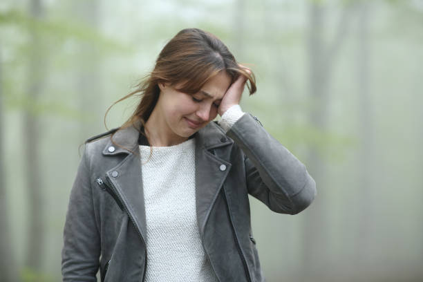 istock Sad woman complaining alone in a foggy forest 1318461036