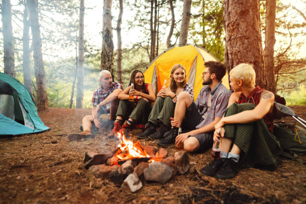 istock Happy campers sitting next to the bonfire and drinking beer 1318461322