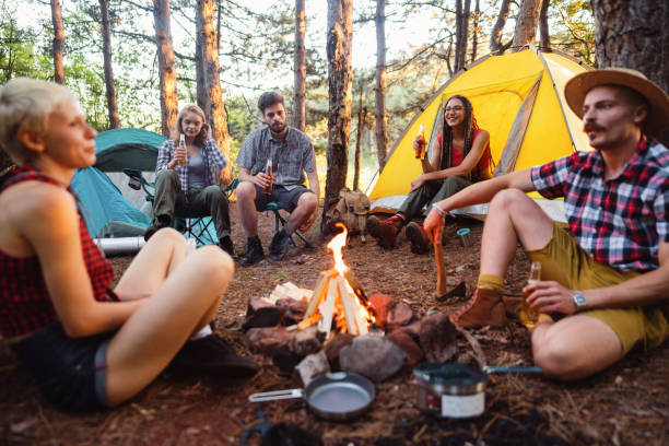 istock Happy campers drinking beer next to the bonfire 1318461383