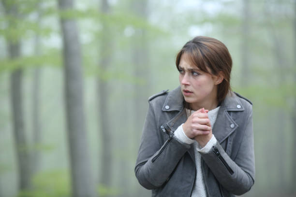 istock Scared woman walking alone in a foggy forest 1318461394