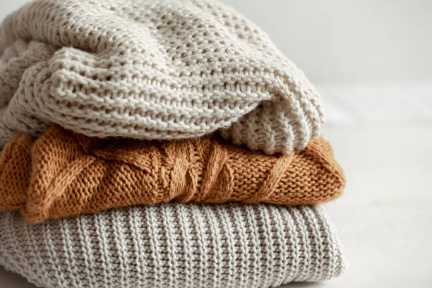 istock A stack of warm knitted sweathers on blurred background. 1318462852