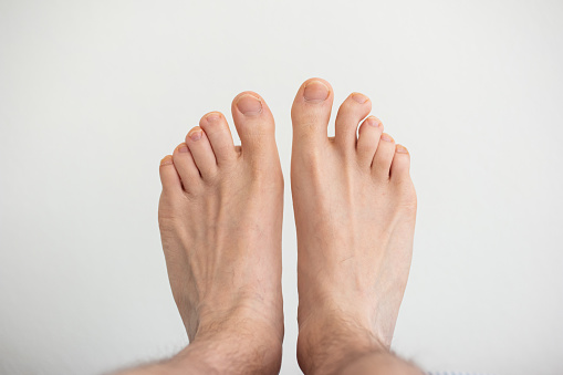 Caucasian male bare feet top view close up shot isolated on white.