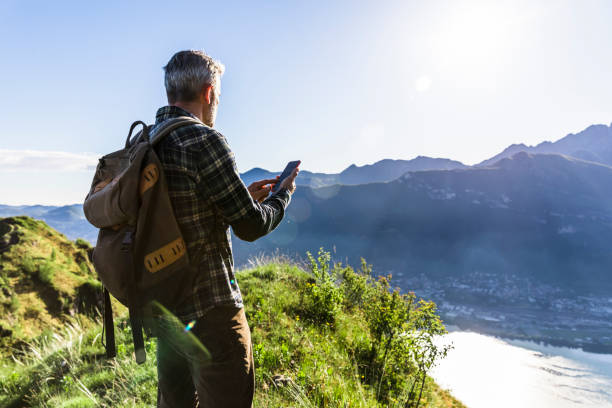 istock Solo hiker using smartphone on top of the mountain 1318466729