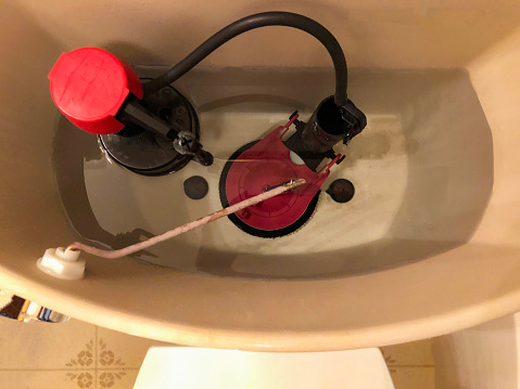 An overhead view of the plumbing inside a toilet bowl flush tank
