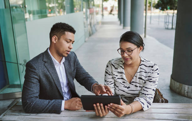 istock Two young businesspeople using a tablet together at a cafe table 1318469472