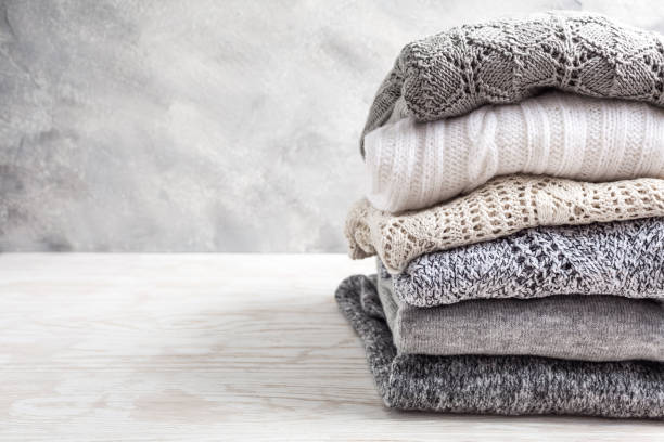 istock Stack of cozy knitted sweaters and pullovers on wooden background 1318470187