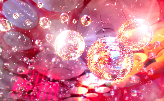 Shining disco balls with laser inside music club, soap suds and confetti floating in the air. Party and clubbing background, digital composite.