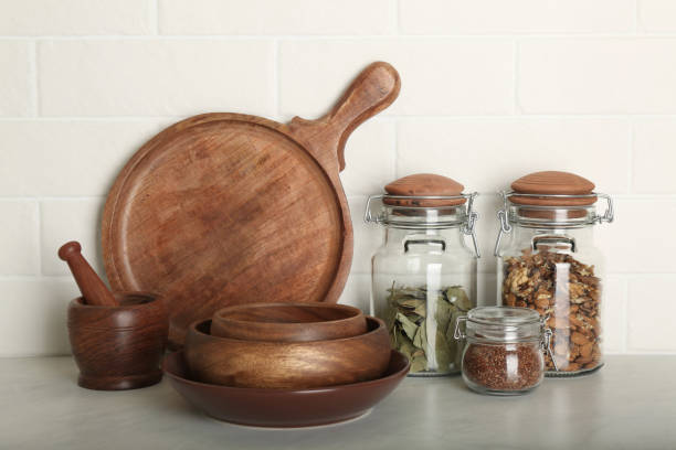 istock Wooden dishware and different products on grey table near white brick wall in kitchen 1318472393