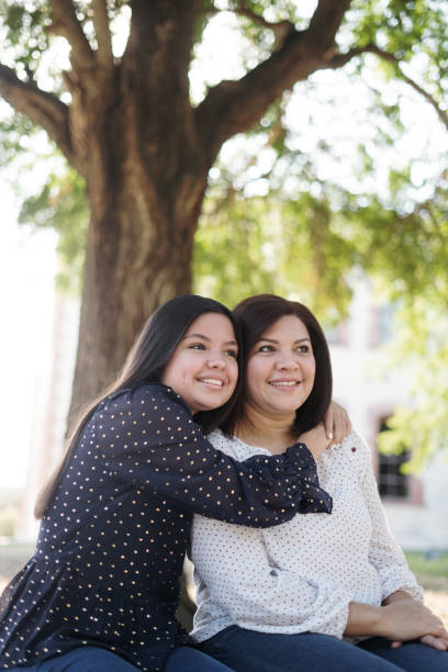 istock Cute latin daughter embracing mother and smiling 1318472519