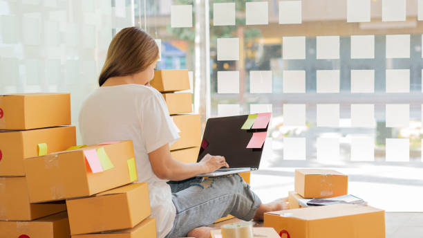 istock Small business owners working with laptops and telephones, mobile and cardboard boxes at work, small business entrepreneurs, SME working with boxes at home, selling online, e-commerce. 1318472706