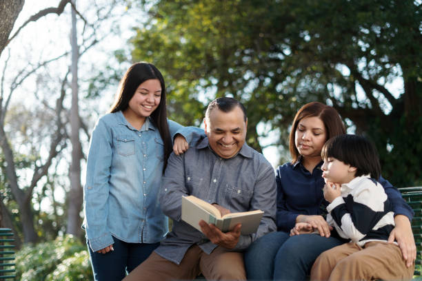 istock Happy family reading book outside 1318472846