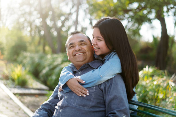 feliz padre e hija latinos disfrutando del tiempo en el parque - park posing family outdoors fotografías e imágenes de stock