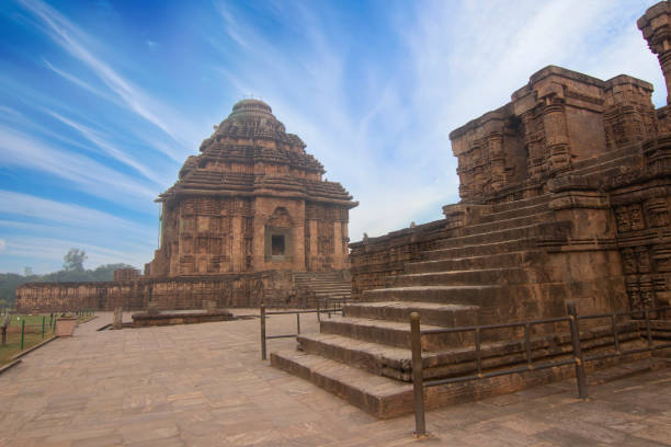 Ancient Indian architecture at Konark Sun Temple. This historic temple was built in 13th century world heritage site. Konark Sun Temple is a 13th-century CE sun temple at Konark about 35 kilometres 22 mi northeast from Puri on the coastline of Odisha, India. The temple is attributed to king Narasingha deva I of the Eastern Ganga Dynasty about 1250 CE. Dedicated to the Hindu sun god Surya, what remains of the temple complex has the appearance of a 100-foot high chariot with immense wheels and horses, all carved from stone. Once over 200 feet high, much of the temple is now in ruins, in particular the large shikara tower over the sanctuary; at one time this rose much higher than the mandapa that remains. chariot wheel at konark sun temple india stock pictures, royalty-free photos & images