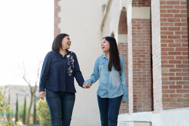 istock Fun mother and daughter holding hands and laughing 1318472959