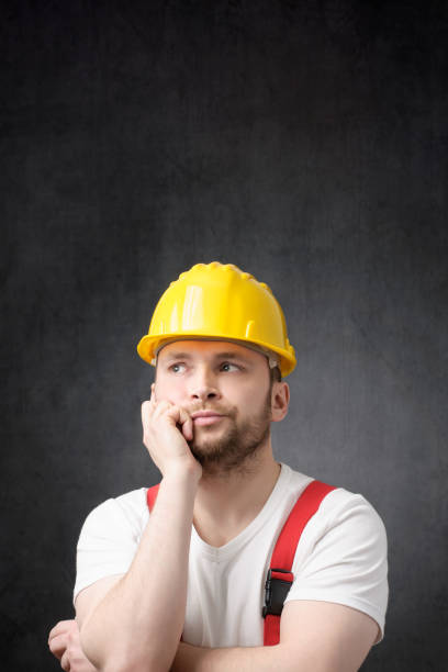 Disappointed construction worker with yellow hard hat Unhappy construction worker with yellow hard hat lazy construction laborer stock pictures, royalty-free photos & images