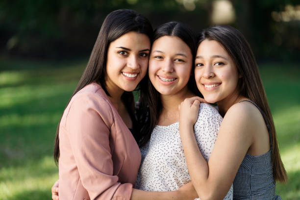 istock Cute latin sisters smiling at the camera outside 1318474160
