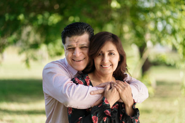 istock Latin husband embracing wife from behind and smiling 1318474957