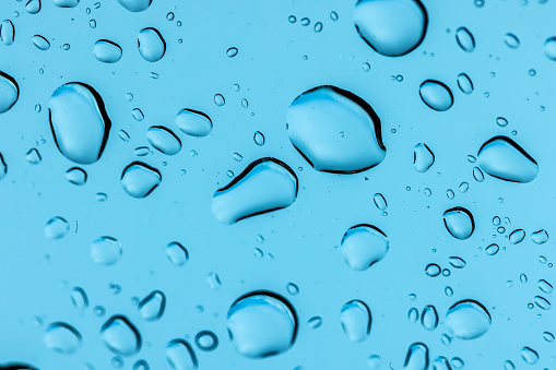 Close up of splashing water droplet. Blue Background