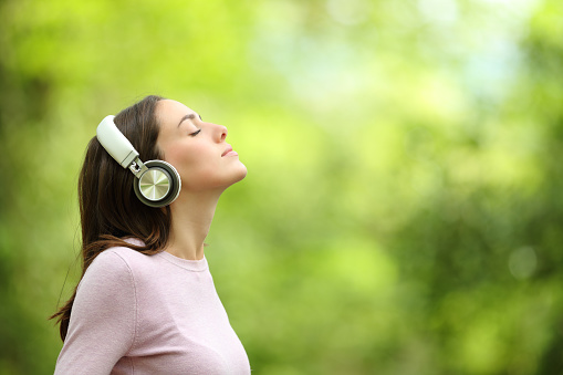Woman meditating listening audio guide with headphones