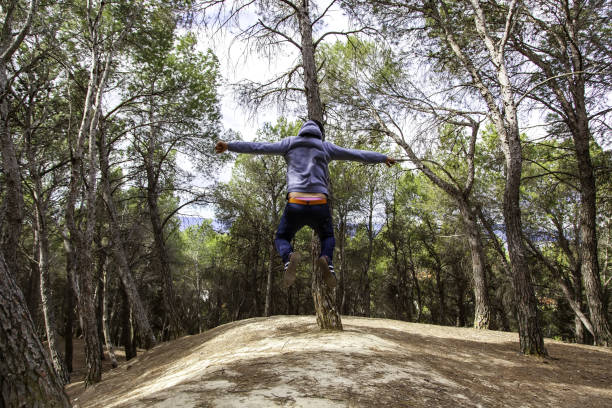 istock Young man jumping in the forest 1318477855