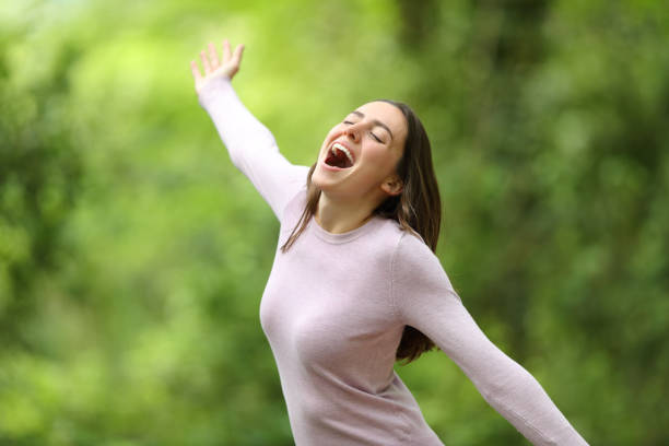 istock Excited woman screaming spreading arms in a forest 1318477875