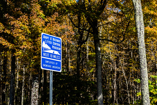 Snowshoe, USA - October 6, 2020: Adopt a highway litter control program sign for next 10 miles with Employees of Snowshoe mountain as sponsor in West Virginia ski resort small town city in autumn