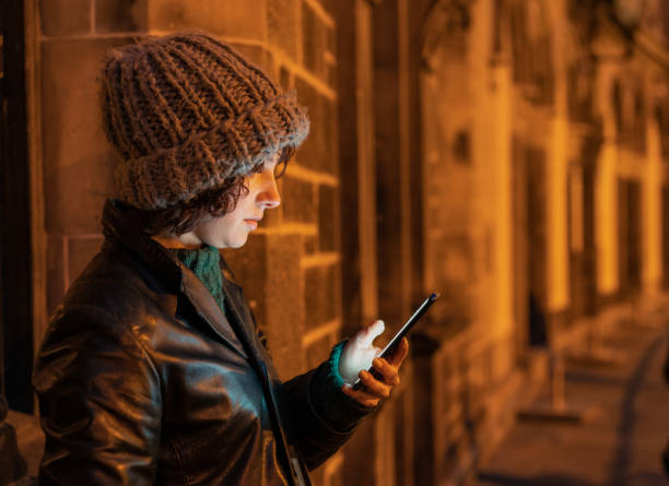 istock A woman checking her phone while waiting for a taxi 1318480874