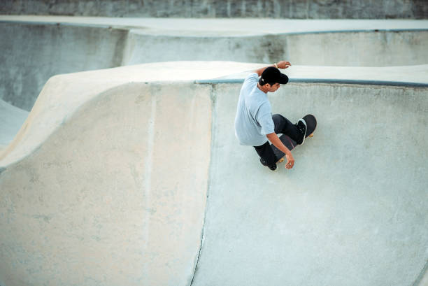 istock Asian male skateboarding in a skate park 1318482162