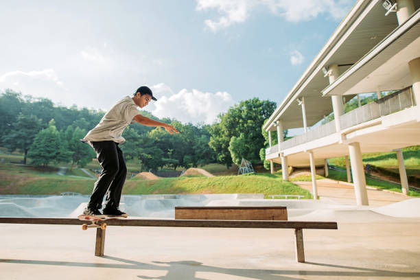 asiatische männliche skateboarding in einem skatepark - extreme skateboarding action balance motion stock-fotos und bilder