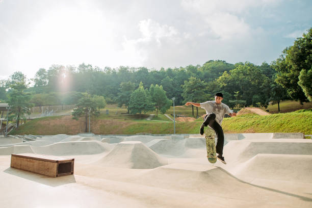 asiatische männliche skateboarding in einem skatepark - extreme skateboarding action balance motion stock-fotos und bilder