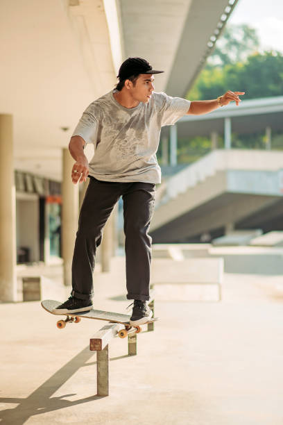 asiatische männliche skateboarding in einem skatepark - extreme skateboarding action balance motion stock-fotos und bilder