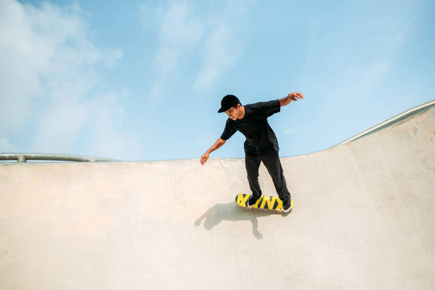 asiatische männliche skateboarding in einem skatepark - extreme skateboarding action balance motion stock-fotos und bilder