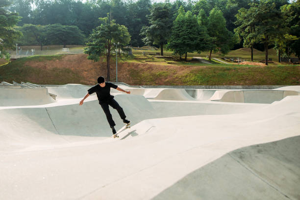 スケートパークでのアジアの男性スケートボード - extreme skateboarding action balance motion ストックフォトと画像