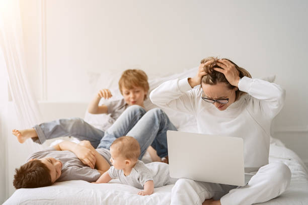 istock Mother working with children and laptop computer at home 1318483288