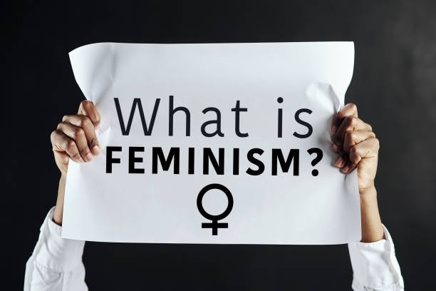 estudio de una mujer irreconocible sosteniendo un cartel con las palabras "¿qué es el feminismo?" en él - me too movimiento social fotografías e imágenes de stock