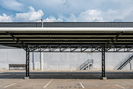 Car park slot with metal roof covered and warehouse distribution on background