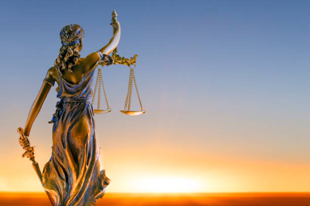 Lady Justice At Sunrise A statue of lady justice looking out towards a rising sun. lady justice photos stock pictures, royalty-free photos & images