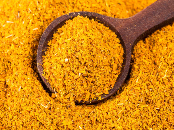 spoon on ground Dried Marigold Flowers closeup top view of wood spoon on pile of ground Imeretian Saffron (Dried Marigold Flowers) closeup substitute for saffron stock pictures, royalty-free photos & images