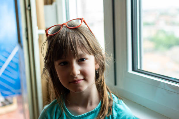 istock Beautiful small girl standing at the window watching. 1318486746