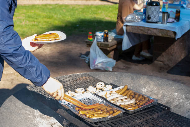 der mann bereitet essen auf dem grill zu. freizeitaktivitäten auf der straße am wochenende. finnland grillplatz im stadtpark. - barbecue grill broiling barbecue vegetable stock-fotos und bilder