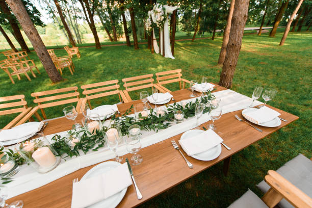 istock Table, chairs and wedding decoration in the forest. Green rustic decor with candles. 1318493627